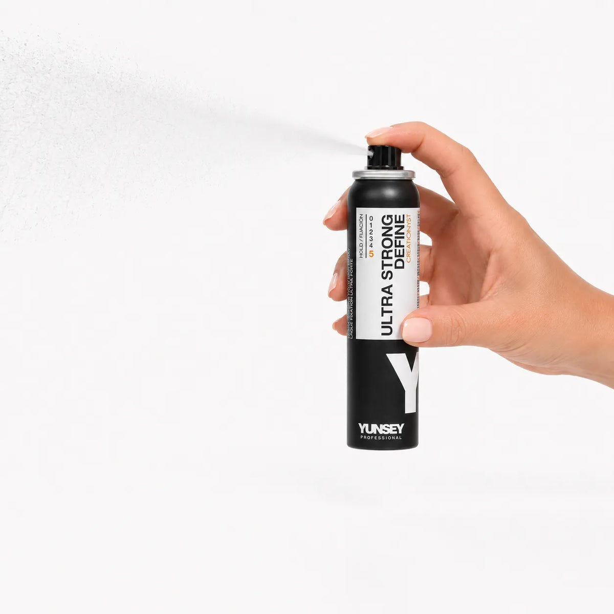 Laca Ultra Strong Yunsey en spray, sostenida con la mano mientras pulveriza una bruma fina para aportar una fijación fuerte y duradera al peinado.