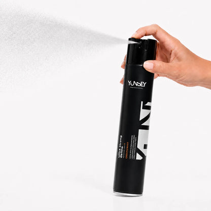 Laca Ultra Strong Yunsey en spray, sostenida con la mano mientras pulveriza una bruma fina para aportar una fijación fuerte y duradera al peinado.